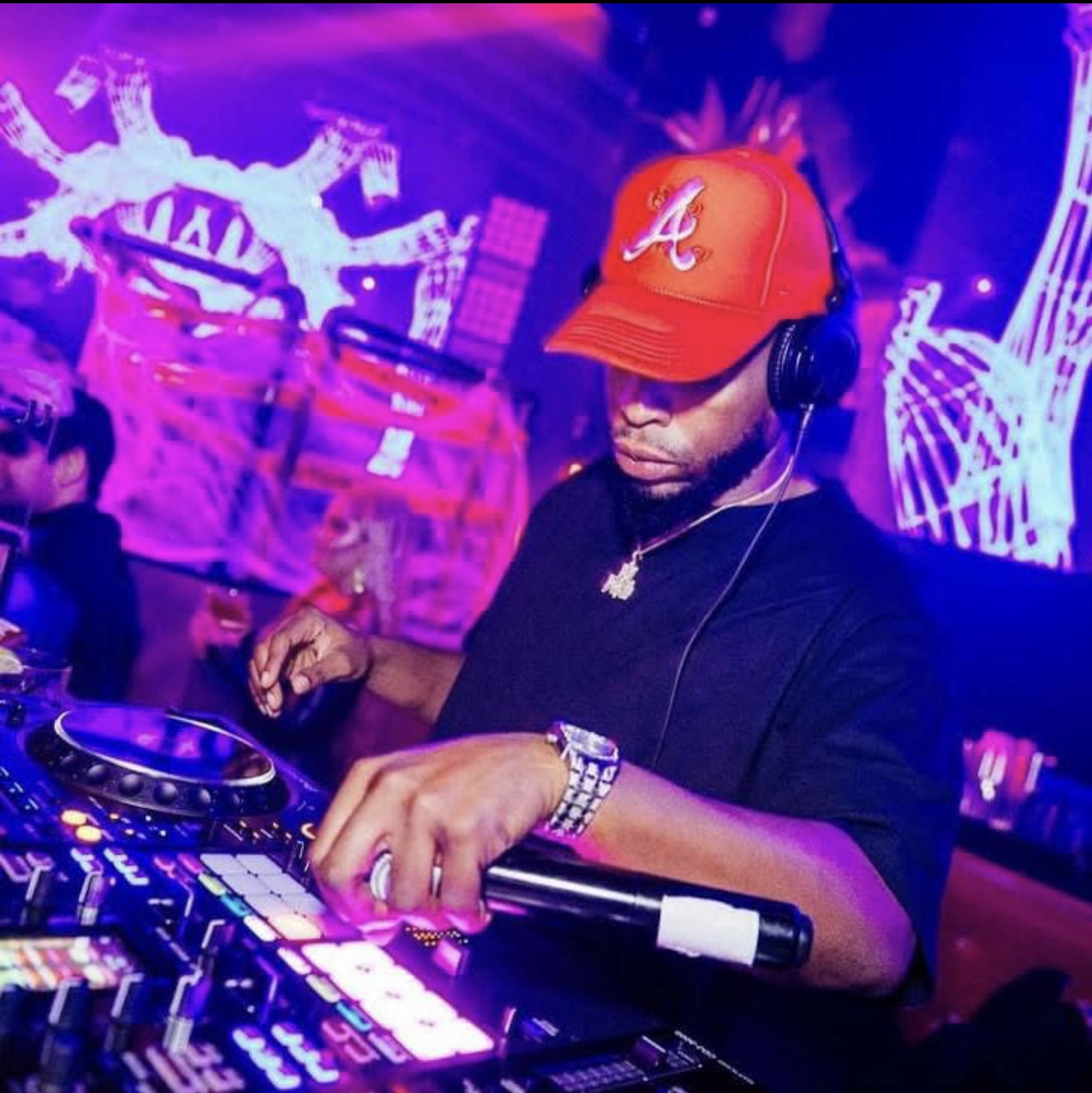 DJ Dutch performing in a club with vibrant purple and pink lights