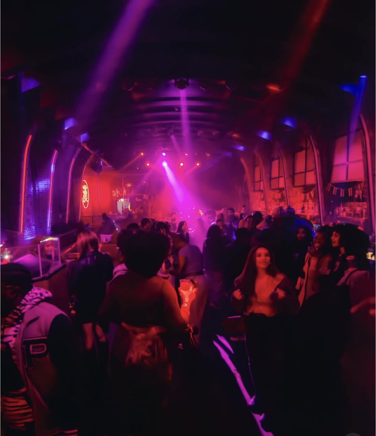 DJ Dutch performing to packed nightclub crowd with vibrant lighting