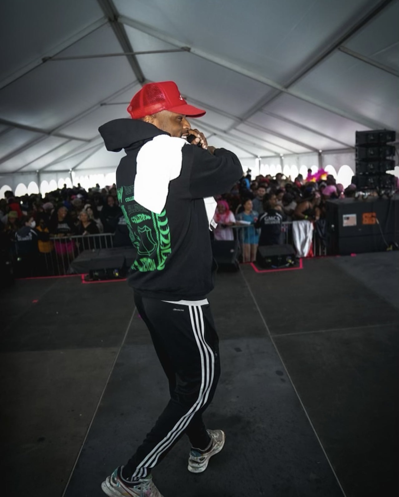 DJ Dutch performing on stage inside a large tent for a festival crowd